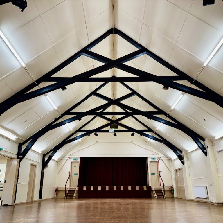 A view of the Main Hall facing the stage area, with upgraded LED lighting.